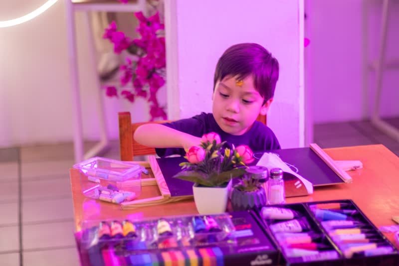 Niño trabajando en su pizarrón con gises de colores