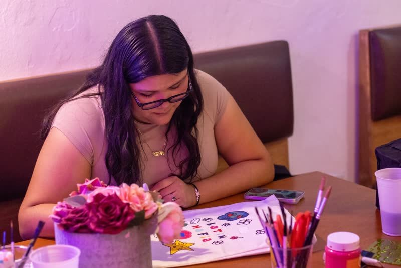 Asistente pintando su diseño sobre la mesa